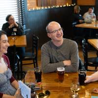 Three guest at event sitting at table and chatting together
